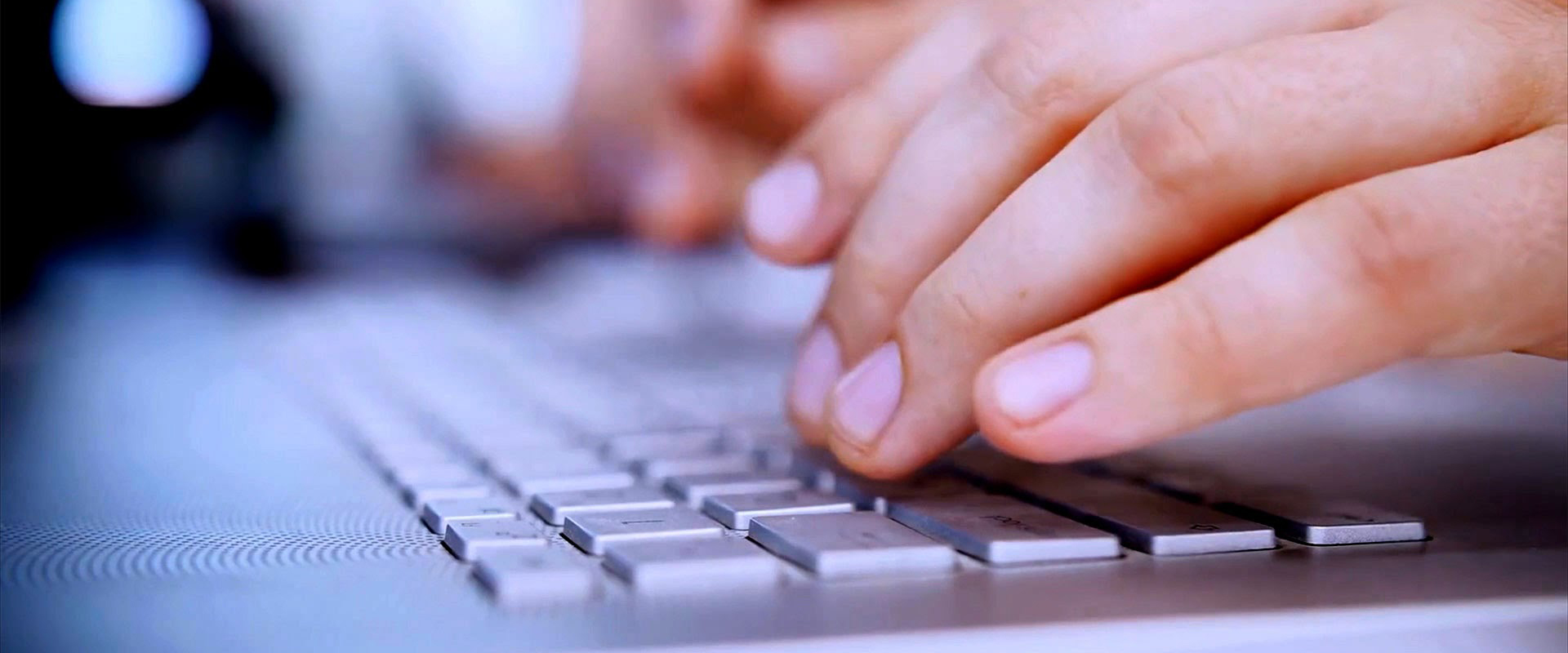 Mani che digitano sulla tastiera di un computer portatile in primo piano